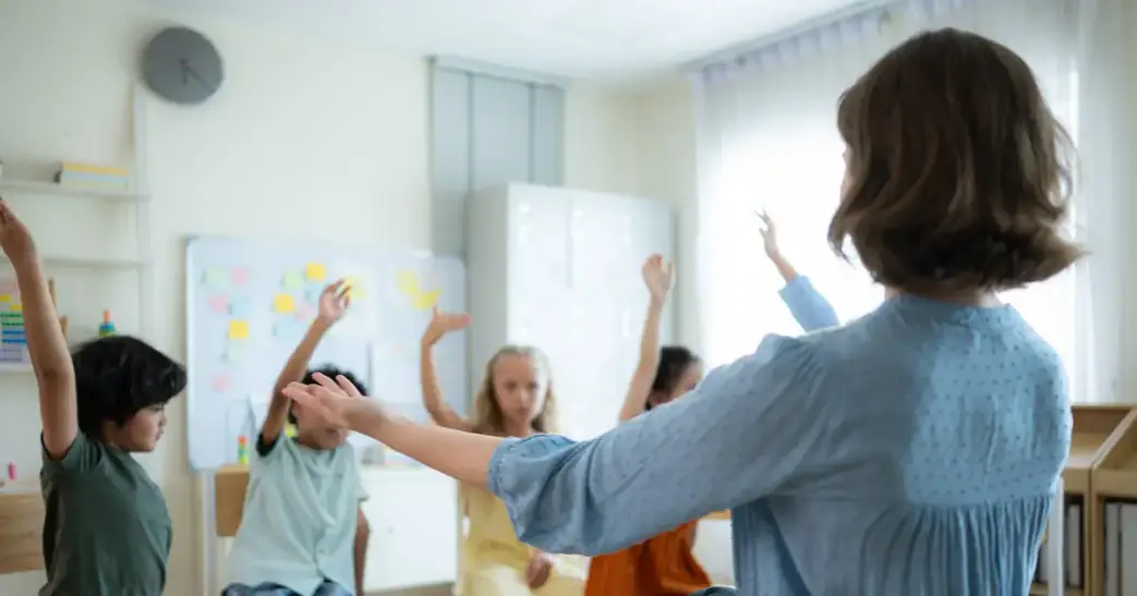 A female teacher teaching students in a classroom.